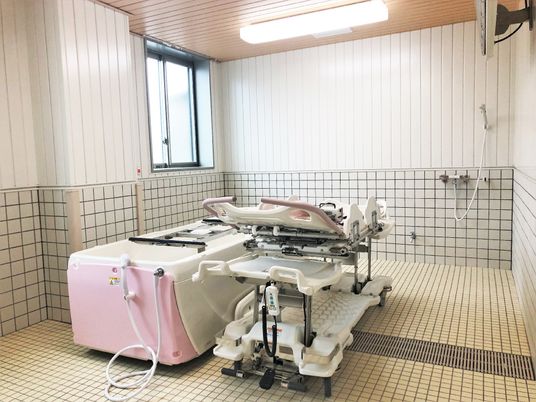 白とピンクの機械浴が置かれた浴室。介護度が高い人も入浴できる設備。