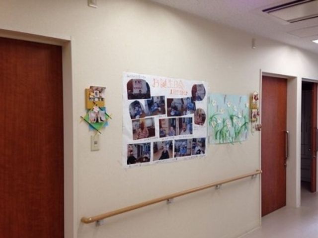 廊下の壁に掲示物 壁写真 廊下の壁には利用者の方々の活動や作品が掲示され、明るい雰囲気を醸し出しています。温もりある環境が働くスタッフをも励ますでしょう。