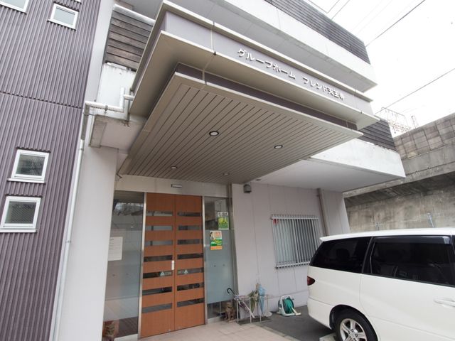 施設のエントランス外観 玄関 落ち着いた色合いの建物入口には、訪れる人々を迎える優しい雰囲気が漂っています。利便性を考慮した設計で、どなたでも安心してお越しいただけます。