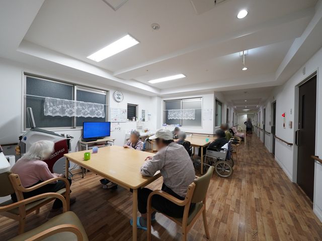 共有スペースでのふれあい 共有スペース ゆったりとした円卓周りで、利用者様が楽しそうに談笑されています。この空間は、コミュニケーションをはぐくむ場として活用されています。