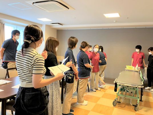 見学中のスタッフと参加者がいる室内  