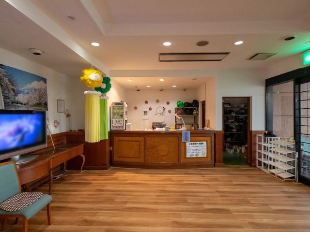温かみのあるロビー風景 受付 広々と開放的な空間で、壁には風景画が飾られ、来訪者を穏やかに迎えます。ゆったりとくつろげる椅子が配置され、訪れる人々の憩いの場となっています。