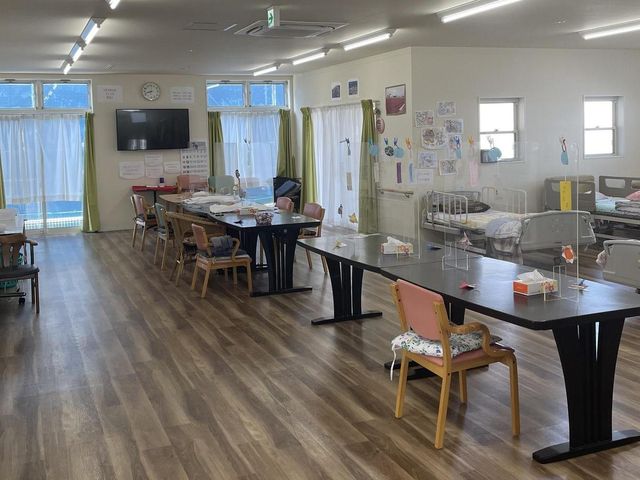 活動スペースの部屋 多目的室 木の温もりに包まれた広々とした空間では、アクティビティが楽しまれています。自然光が優しく差し込みます。