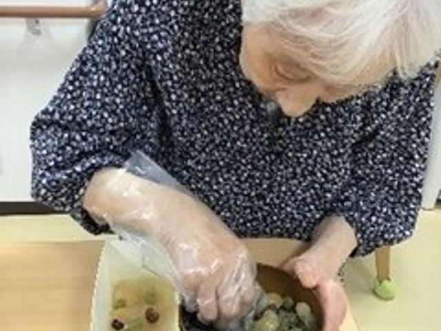 手作業をする高齢者 日常風景 手先を動かしながら楽しむアクティビティが行われる空間です。日々の生活に彩りを加える、暖かい雰囲気が伝わってきます。