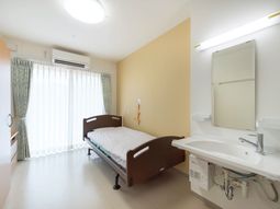 明るい病室のベッドと洗面台