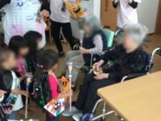 楽しげな交流の様子 ラウンジ 子どもたちと高齢者が楽しそうに交流しています。明るい雰囲気の中で、笑顔が広がっています。