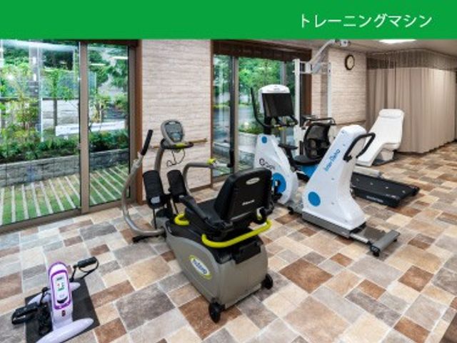 機能訓練室のトレーニング機器 機能訓練室   窓から光が入る明るい空間に、トレーニング機器がゆったり配置されています。運動しやすい広さがあり、就業先としても動線を確認しやすいです。