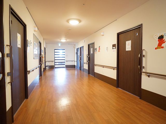 温もりのある廊下の様子 廊下 清潔感あふれる廊下です。手すりが整備され、壁には温かみのある飾りがあり、安全かつ心地よい空間が広がっています。