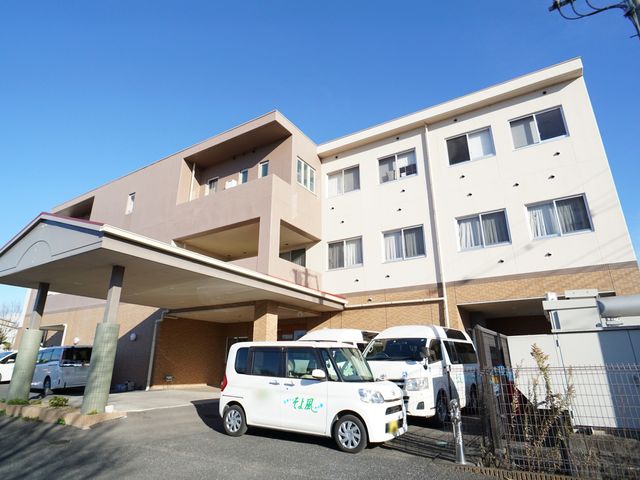 清潔感のある建物外観 外観 明るい色調で設計された建物は、清潔感があります。玄関前には利用者の送迎に使われる車が停まっており、アクセスの良さが伺えます。