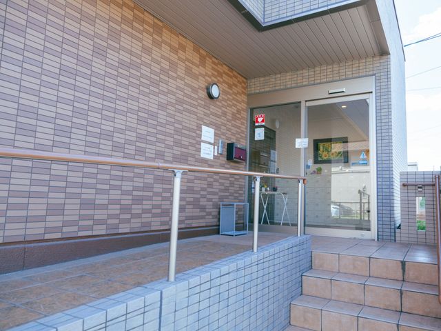 エントランスの明るい景観 エントランス 手すりが設置された入口はバリアフリー設計で、安全にお越しいただける環境が整っています。