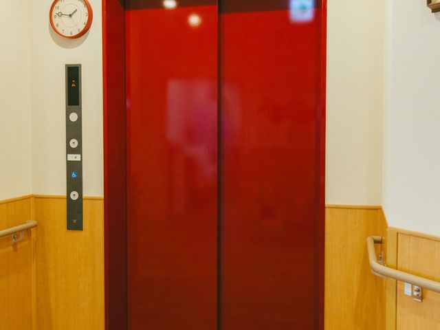 赤い扉のエレベーター エレベーター 落ち着いた色合いのエレベーターは、手すりが設置されており、利用者の安全に配慮した設計です。