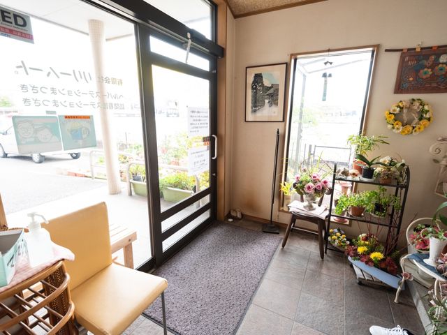 明るいエントランスの風景 玄関 花々で彩られた温かみのある待合スペースです。日差しが差し込むこの場所で、訪問者の方々をお迎えしています。