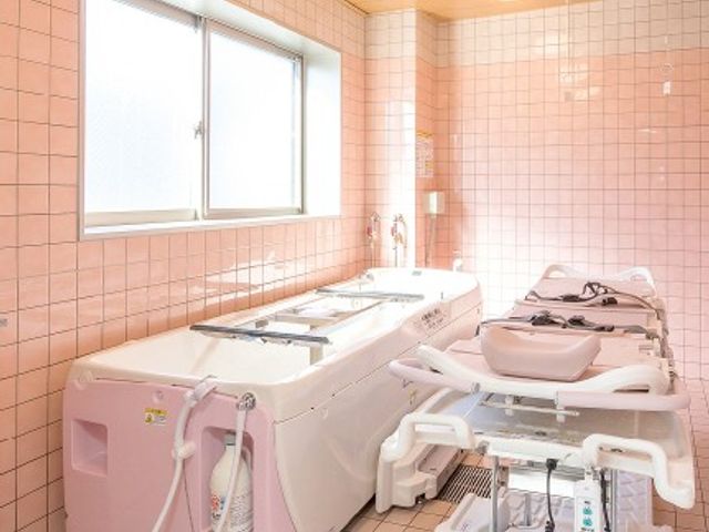 ゆとりある浴槽の浴室 浴室 自然光が優しく入る、設備が整った快適な空間です。温かみのあるピンクのタイルが特徴的です。