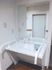 白く大きな洗面台には大きな鏡があり、両脇に手すりもついている。フットレスの洗面台は車椅子をご利用の方にも安心である。