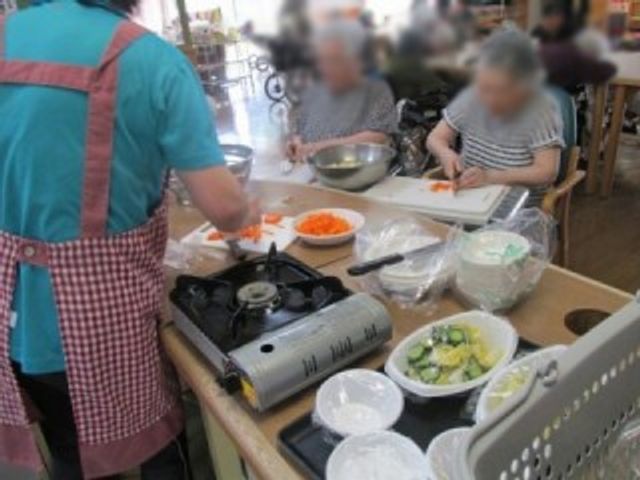 調理活動の様子 キッチン 利用者の方々が野菜の調理を楽しむ活動です。和やかな雰囲気が漂っています。