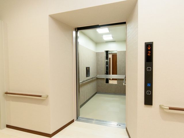 手すり付き廊下とエレベーター エレベーター 手すりが設置された清潔な廊下が、広々としたエレベーターへと続いています。快適な移動をサポートする設計で、あなたの働きやすさも考えた環境です。