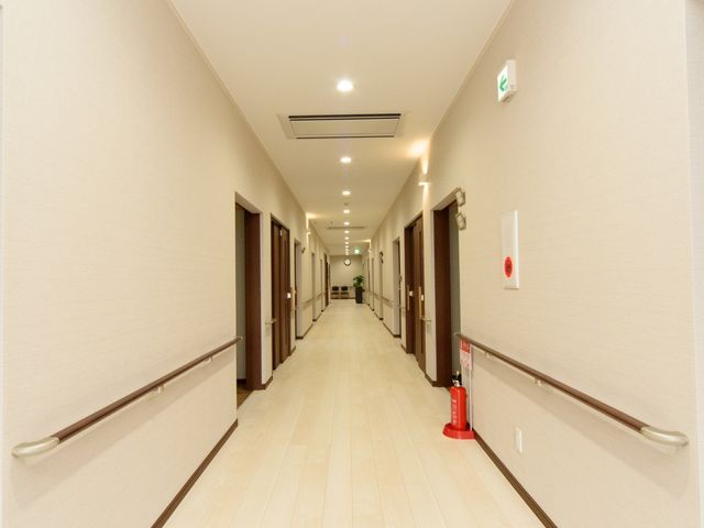 清潔感のある廊下 通路 手すり付きで広々とした通路です。落ち着いた色合いで、快適にお過ごしいただける設計になっています。