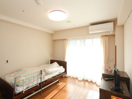 居室は窓から明るい光が差し込む。エアコン付きで室温調節可能。ベッドからTVが見やすく収納スペースも十分で生活がしやすい。
