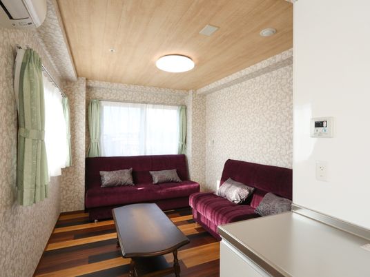窓が多く明るくて風通しの良い居室。ソファーが２つあり多くの来訪者様と自由な時間を過ごすことができる。