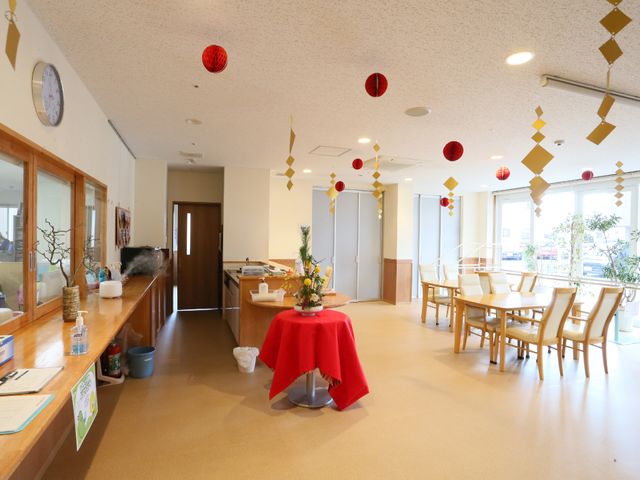 共用エリアの明るい空間 エントランス1 ゆったりとしたダイニングで食事の時間をお過ごしいただけます。天井から吊るされた装飾も季節感を演出しており、居心地の良いひと時をサポートします。