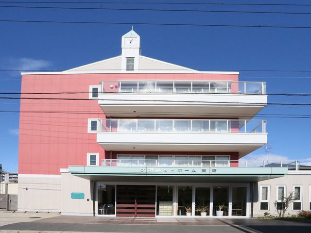 ピンクの壁の建物外観 外観 開放的な正面入口のあるピンク色の建物です。広々とした明るい環境がお迎えします。