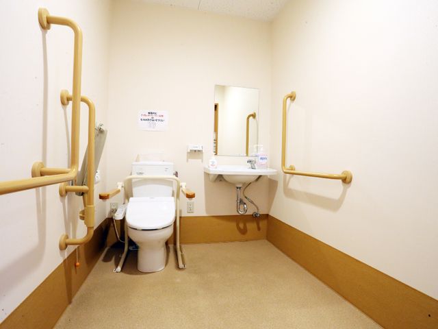 バリアフリートイレ トイレ 手すり付きで安全性を考慮したトイレです。広々として動きやすく、柔らかい色使いで温もりを感じられます。