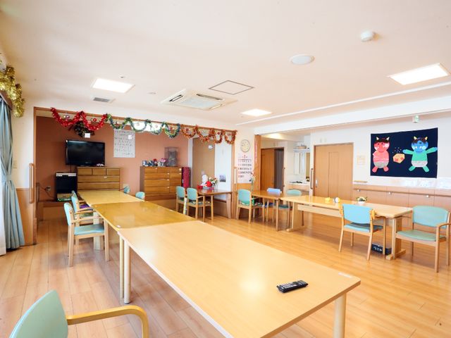 飾り付けのある居室空間 ダイニング 飾り付けが施された広々とした食堂で、皆が集まる心地よいコミュニケーションの場を提供しています。明るく開放的な雰囲気の中、様々な活動が行われることでしょう。