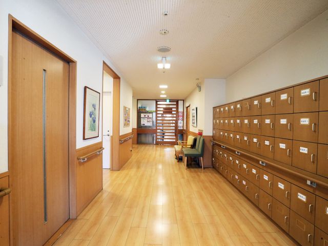 廊下と郵便ポストの風景 エントランス ゆとりのある廊下が整った環境で、壁面にはアートが飾られています。通り抜ける際にも明るい印象を受ける設計です。
