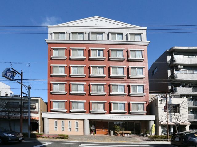 赤茶色の建物の外観 外観 清潔感のあふれる建物前には、アクセスしやすい平坦な入口があり、訪れる方を温かく迎えます。