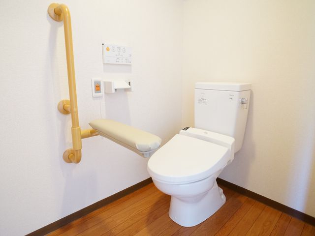 バリアフリートイレ設備 トイレ 手すり付きのトイレは、安全と利便性を考えた設計です。利用者の自立支援に配慮し、ゆったりと過ごせる空間が整っています。