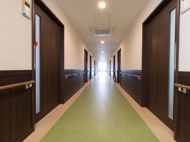 清潔感のある廊下 廊下 手すりが設置された明るく広々とした通路です。安全に配慮された設計で、快適にご勤務いただける環境が整っています。