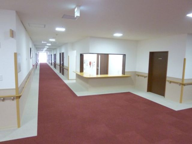 明るい廊下の定点視点 通路 広々とした通路は、柔らかな照明と手すりが設けられ、歩行が快適な環境を提供しております。
