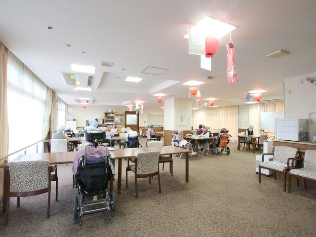 広々とした居心地の良い食堂 リビング 広々とした食堂では、利用者さまが集って様々な活動を楽しんでいます。明るく開放的な雰囲気の中で、心地よい時間を過ごすことができます。