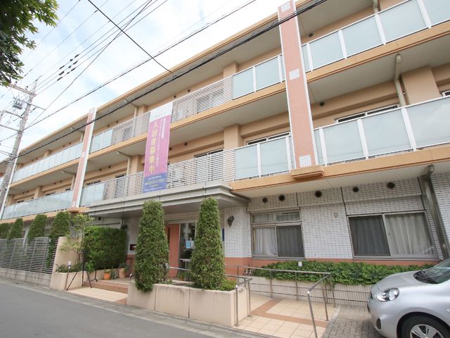 清潔感のある建物の外観 外観 閑静な街並みに溶け込む落ち着いたデザインの建物です。建物前の多くの緑も心地よく、歓迎の雰囲気を感じさせます。