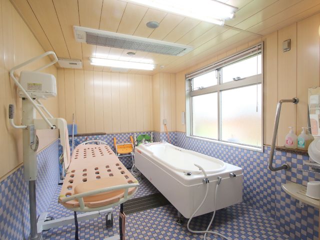 バリアフリー対応の浴室 介護浴槽 ゆとりのあるスペースの浴室で、安心してご入浴いただける環境が整っています。手すりやベッド型の入浴補助具も設置されております。