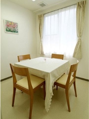 清潔な食事エリア 談話室 窓から明るい光が差し込む食事スペースです。ゆったりとした椅子が配置され、落ち着いて食事ができる環境が整っています。