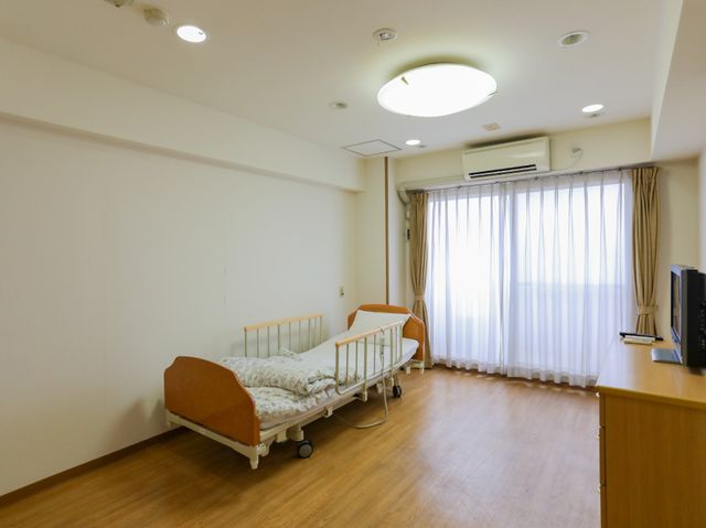 居室のシンプルな内装 居室 広々とした部屋には必要最低限の家具が配置され、清潔感があり落ち着いた雰囲気を演出しています。ゆったりとした空間で働ける環境が整っています。