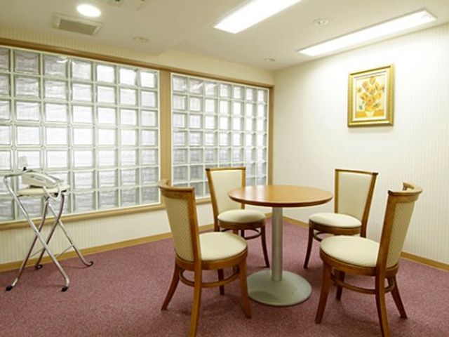 居心地の良い休憩室 共有スペース ゆったりとした休憩室では、木製のいすに腰掛けて、穏やかな時間を過ごせます。窓辺には自然光が差し込み、温もりある空間が広がっています。