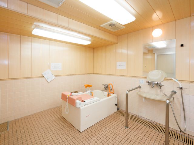 ケア施設の浴室 浴室 ゆとりある設計の清潔な浴室です。手すりや高さ調節が可能な椅子も完備しており、安全に配慮した設備が整っています。