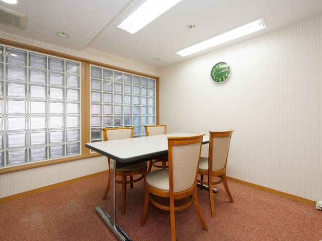 ガラス窓とテーブルの居室 共有スペース 落ち着いた色合いの居室です。やわらかな光が差し込むテーブル周りで、憩いの時間を過ごせそうです。