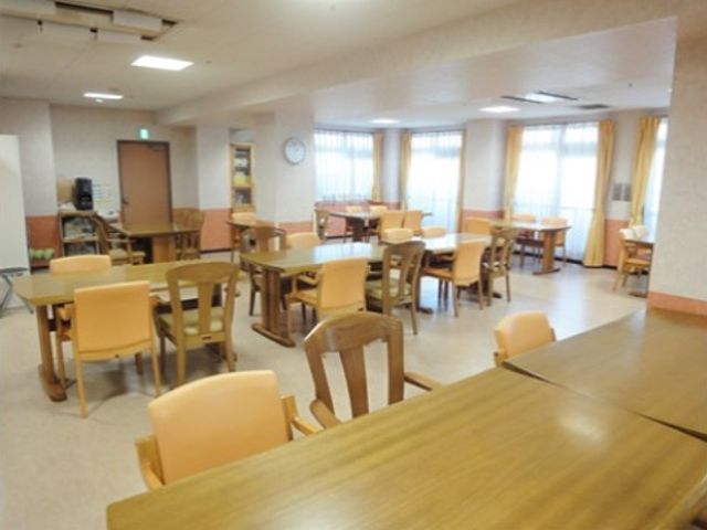 広々とした明るい食堂 食堂兼機能訓練室 温かみのある木目調の食堂は、共有の食事や憩いの空間としてゆったりとお使いいただけます。窓からの自然光が心地よい雰囲気を醸し出しています。