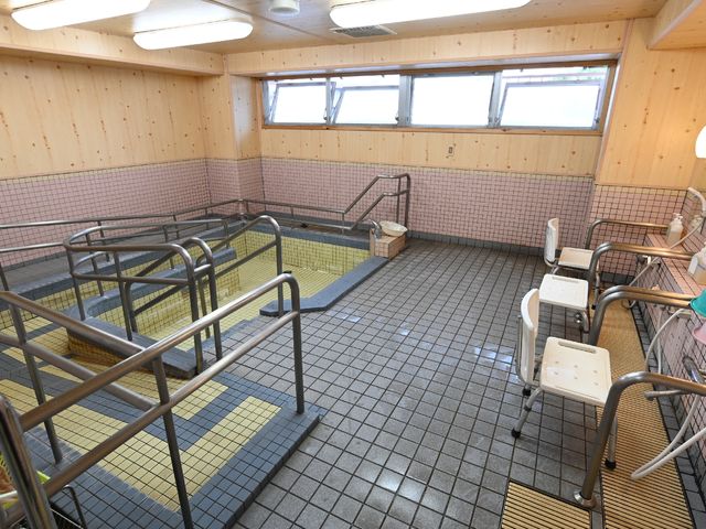 無障害設計の浴室 浴室 手すりや座席付きで安全を考えた清潔な浴室です。利用者が安心して入浴できるように配慮されています。