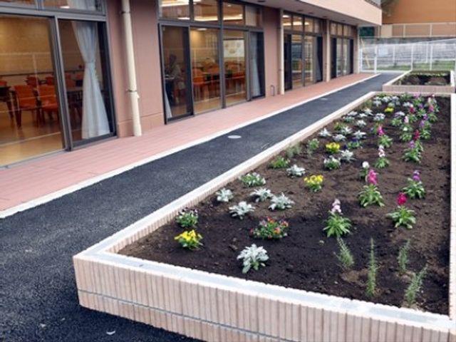 中庭の華やかな花壇 菜園 ガラス越しに暖かな光があふれるダイニングを望む中庭です。四季折々の植栽が楽しめる設計となっております。