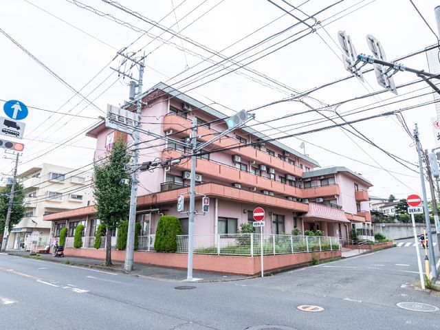 街角に佇むピンクの建物 外観 都会の一角にある落ち着いたピンク色の建物です。周辺は静かな住宅街で、快適な勤務環境が期待できそうです。