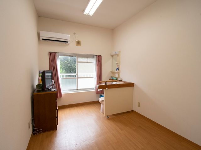 居心地の良い居室 居室 落ち着いた色合いで統一された居室です。エアコンやテレビ設備が整い、快適に過ごせる空間が確保されています。