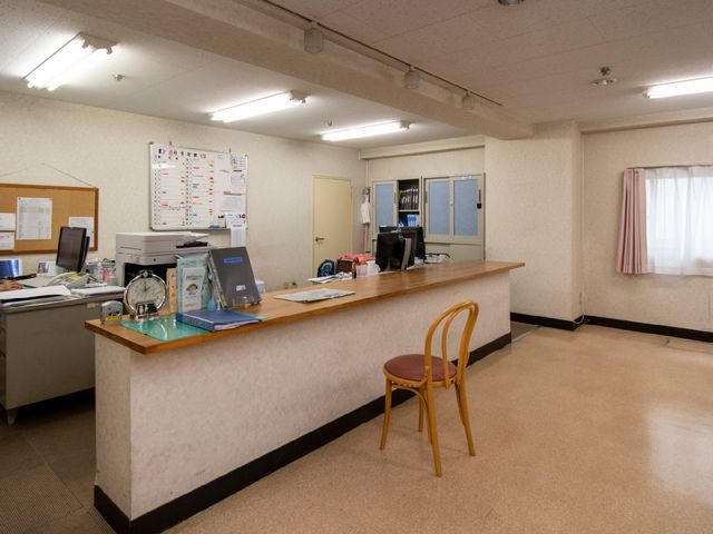 受付と掲示物のあるフロント 受付 広々とした受付スペースは整理された環境で、スタッフの対応もスムーズに行われています。様々な情報が掲示された掲示板があるため、日々の業務に必要な情報を素早く把握することができます。