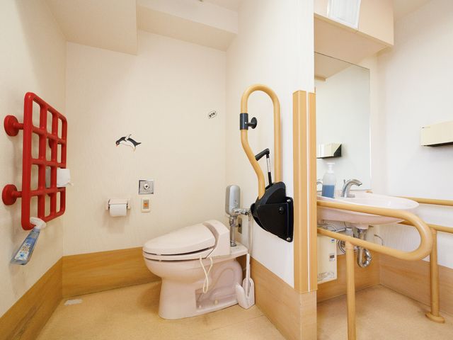 バリアフリーのトイレ設備 トイレ 安全なサポートバー付きの清潔なトイレ空間です。利用者の自立支援と安全確保に配慮しています。