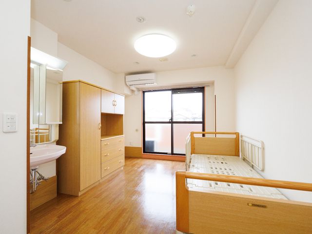 明るい居室の様子 居室 広々とした居室には、手すり付きのベッドや洗面台が備えられ、日常生活が快適に過ごせるように配慮されています。