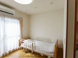 明るい居室のベッドと窓