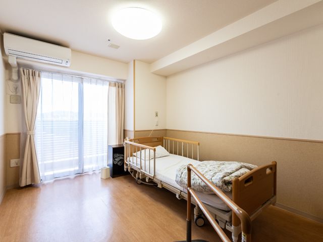 清潔感ある居室空間 居室 日当たりの良い、ゆったりとした居室です。シンプルで機能的なベッドや家具が配置され、快適な日々を支えます。